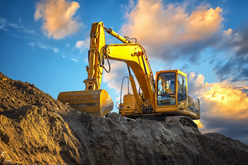 A stopping yellow excavator at an incredibly beautiful sunset A stopping yellow excavator at an incredibly beautiful sunset